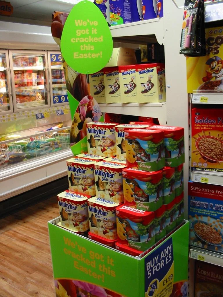 Sezónny POS stojan s veľkonočným tovarom a tematickým označením v predajni