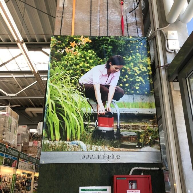 Reklamný banner namontovaný na stene v interiéri prevádzky
