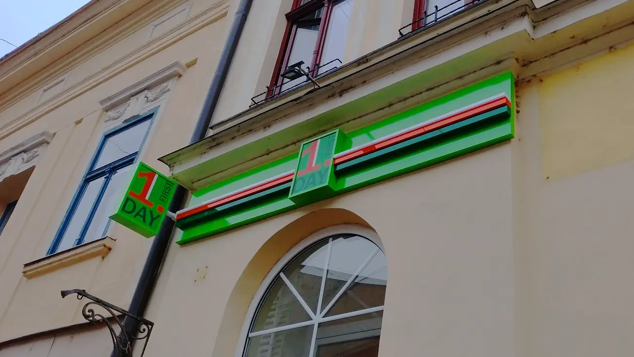 Fasáda prevádzky First Day so svetelným označením a reklamnými výstrčami