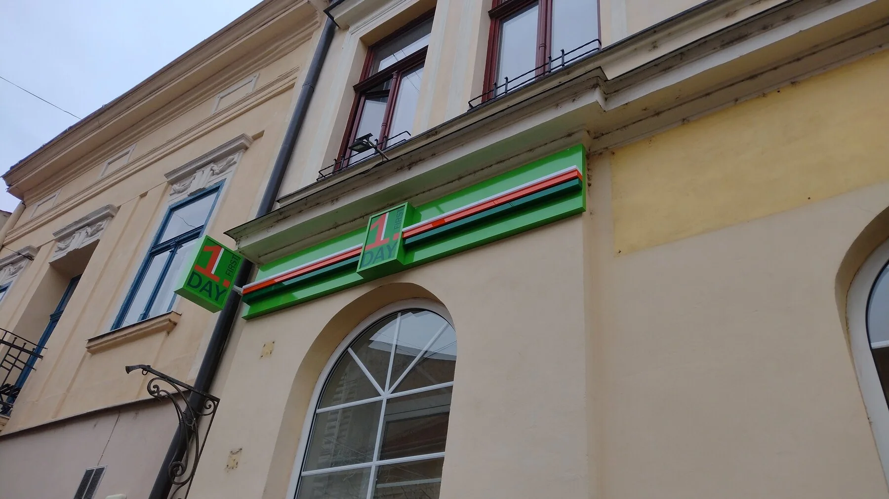 Fasáda prevádzky First Day so svetelným označením a reklamnými výstrčami